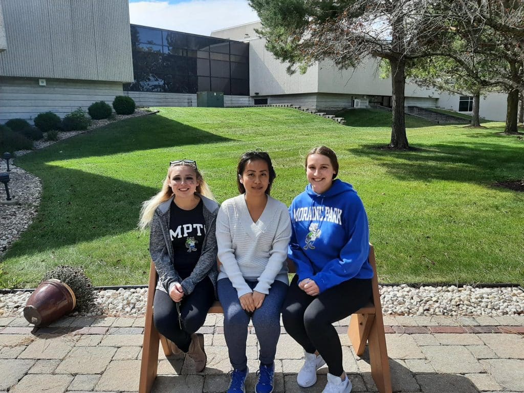 President Eva Knappenberger, Vice President Mina Vang-Xiong, and Secretary Emily Vicksitting on a bench.