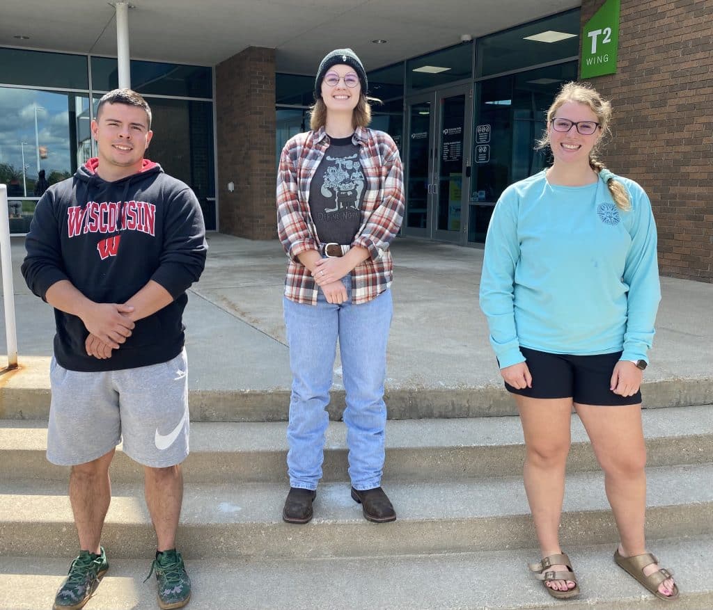 Vice President Wesley Kane, President Aspyn Koslowski, and Secretary Haley Van Raden standing in front of the Moraine Park West Bend Campus entry.