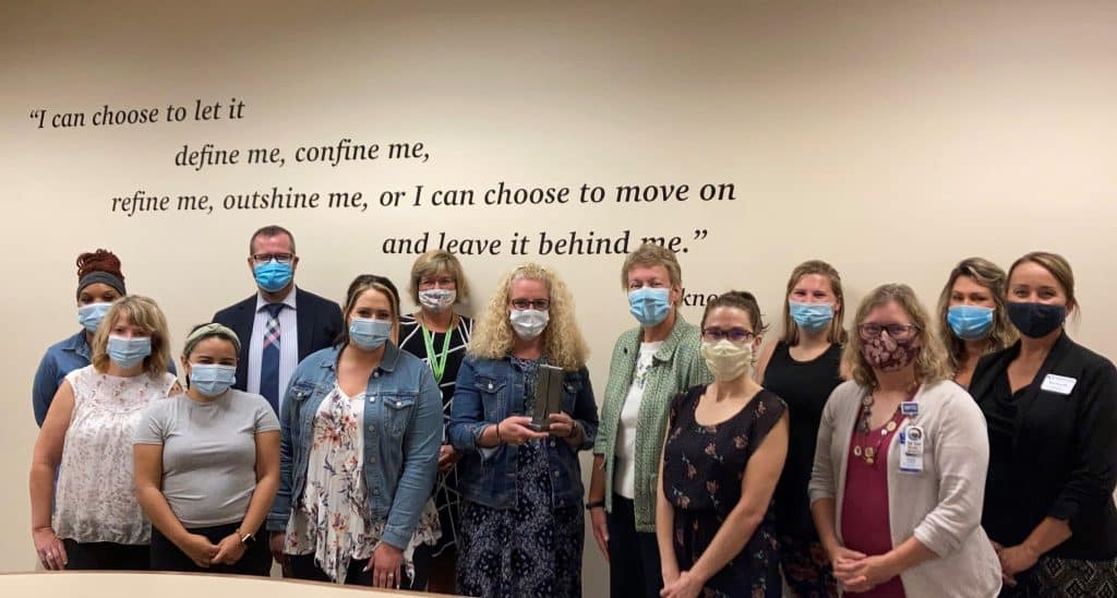 Group picture of 13 individuals. Their names areChastity Bolden-ASTOP, Michelle Boodry-ASTOP, Sydney Barrueta-ASTOP, Ben McKenzie-MPTC Associate Dean, Rhianna Zuleger-ASTOP, Barb Jascor – MPTC Dean, Nicole Krause-ASTOP Executive Director, Bonnie Baerwald-MPTC President, Terri Alexander-ASTOP, Sarah West-ASTOP, Anne Lemke-MPTC Community Impact Coordinator, Jessica Bielmeier-ASTOP, Bobbi Fields-MPTC Associate Dean.