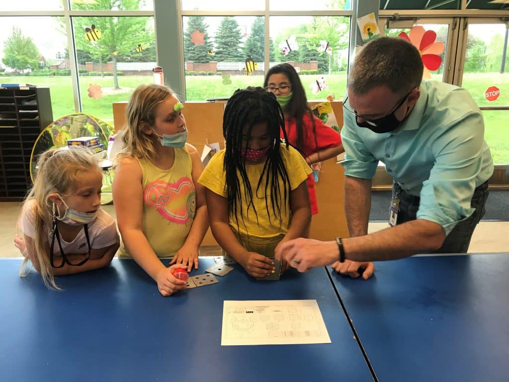 Beau Gelllings, MPTC EWD Business Representative, demonstrates a fun metal welding cube puzzle to Jackson BGC teens using a blueprint drawing of directions for building the cube.