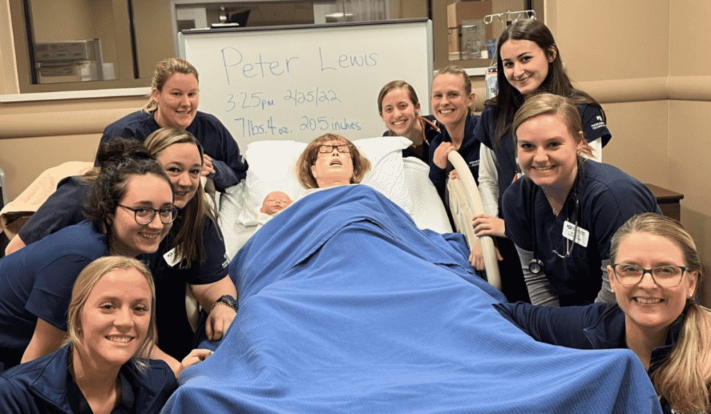 Nursing students in the simulation center smiling at camera