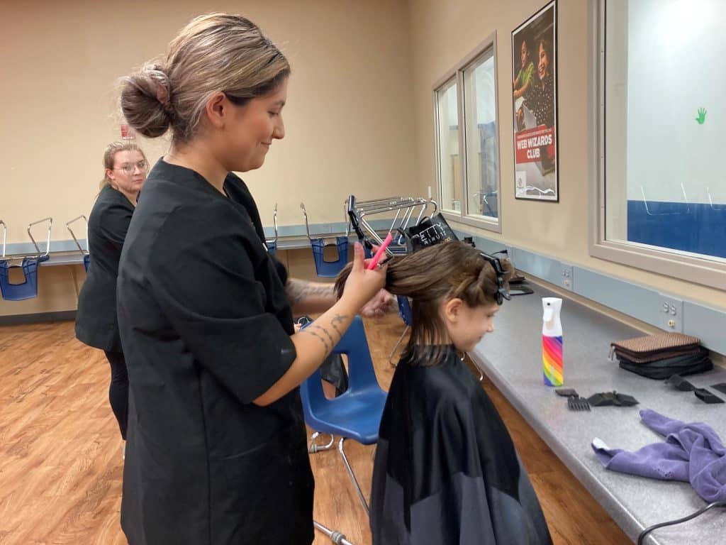 MPTC Cosmetology Student Abby Prim cutting a teenager's hair.