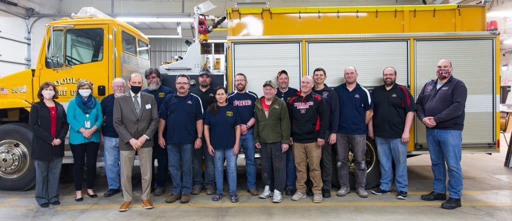 Group photo of Dana Bourland, director of college advancement at Moraine Park; Barb Jascor, dean of health and human services at Moraine Park; Werner Lehnert, Woodland Fire Department; Paul Lehnert, Woodland Fire Department; Donny Zimmerman, Woodland Fire Department; Craig Becker, Woodland Fire Department; Rick Kling, Woodland Fire Department; Alex Braunschweiger, Woodland Fire Department; Rick Schumacher, Woodland Fire Department; Jeremy Lackas, Woodland Fire Department; and Aaron Paul, fire instructor at Moraine Park. Front row (left to right) are Dr. Jim Eden, VP of academic affairs at Moraine Park; Tony Roethle, Woodland Fire Chief; Nicki Roethle, Woodland Fire Department; Charles Hagen, Woodland Fire Department; and Andrew La Cross, Woodland Fire Department.