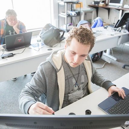 male student in classroom on computer