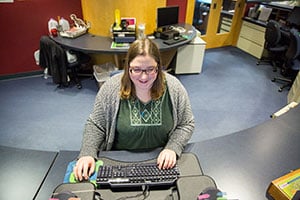 female student sitting at desk using computer