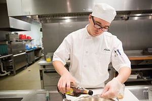 male culinary student preparing food