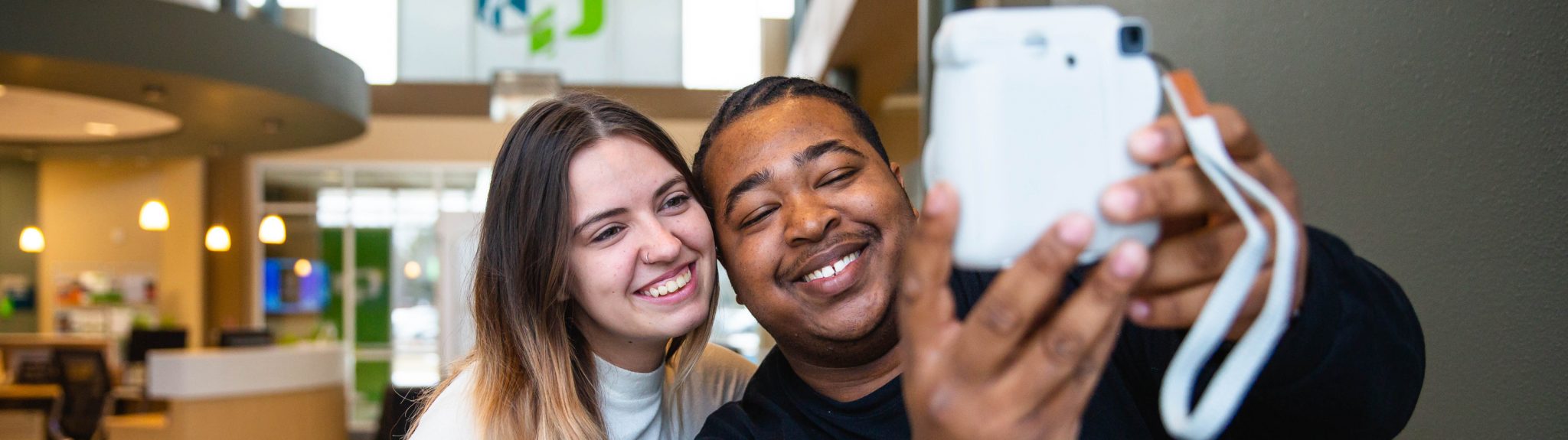 two students taking a selfie with a camera