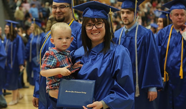 graduate holding child
