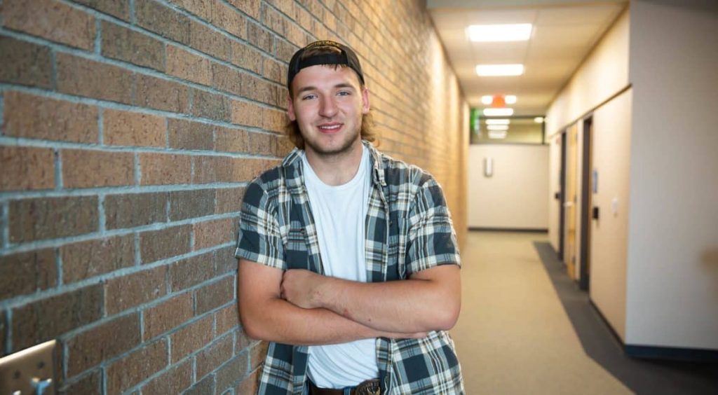 Student named Mason leaning at the wall.