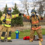Two fire fighters fist-bumping.