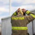 Fire figher wearing their uniform with the name Beaver Dam on it.