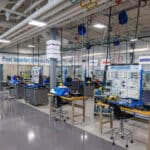 Numerous manufacturing equipment located in the clean and spacious AIR Center. The wall contains plaques highlighting sponsors.