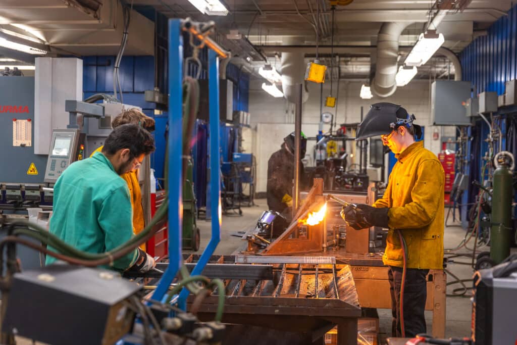 Two welding students welding in the workshop.