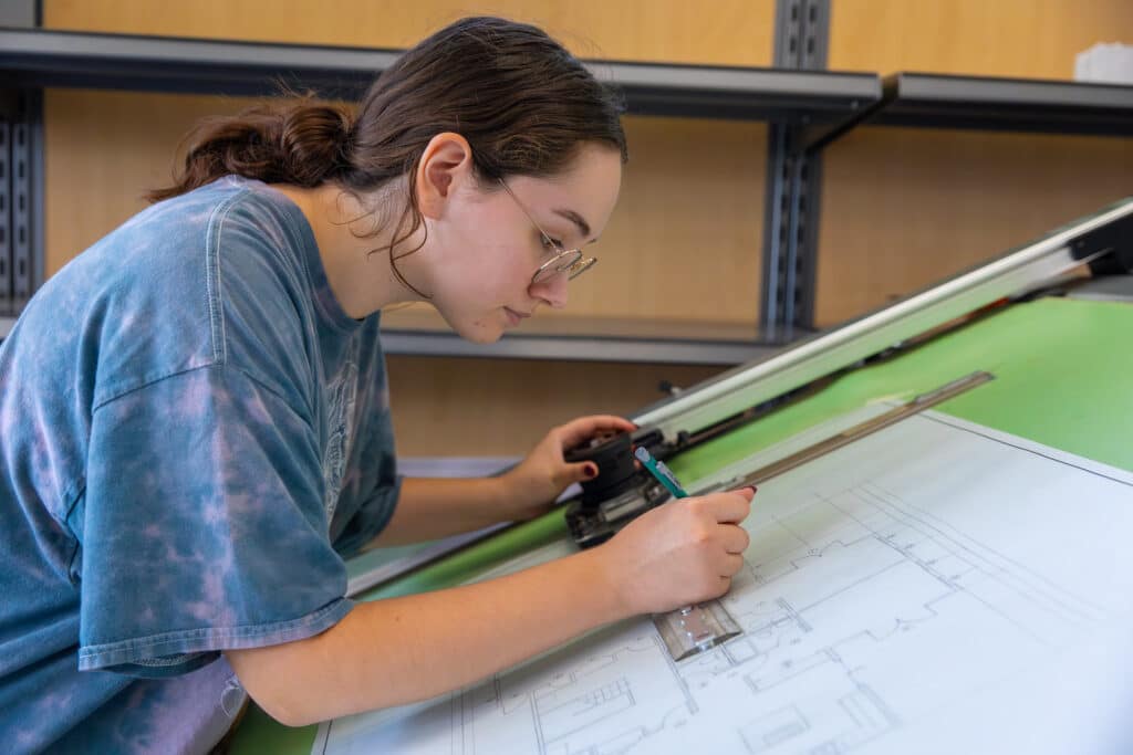 Architectural Technology program student working on a big drawing board.
