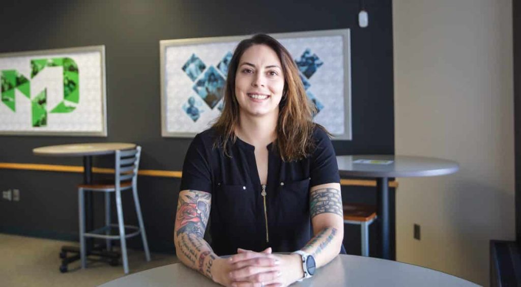 Amanda Kollmorgan, 2021-22 District Student Ambassador, sitting at the desk and smiling into the camera.