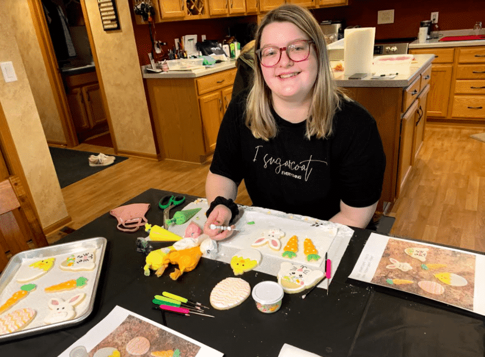 Student Amanda Rogers sitting at a table creating cookies.