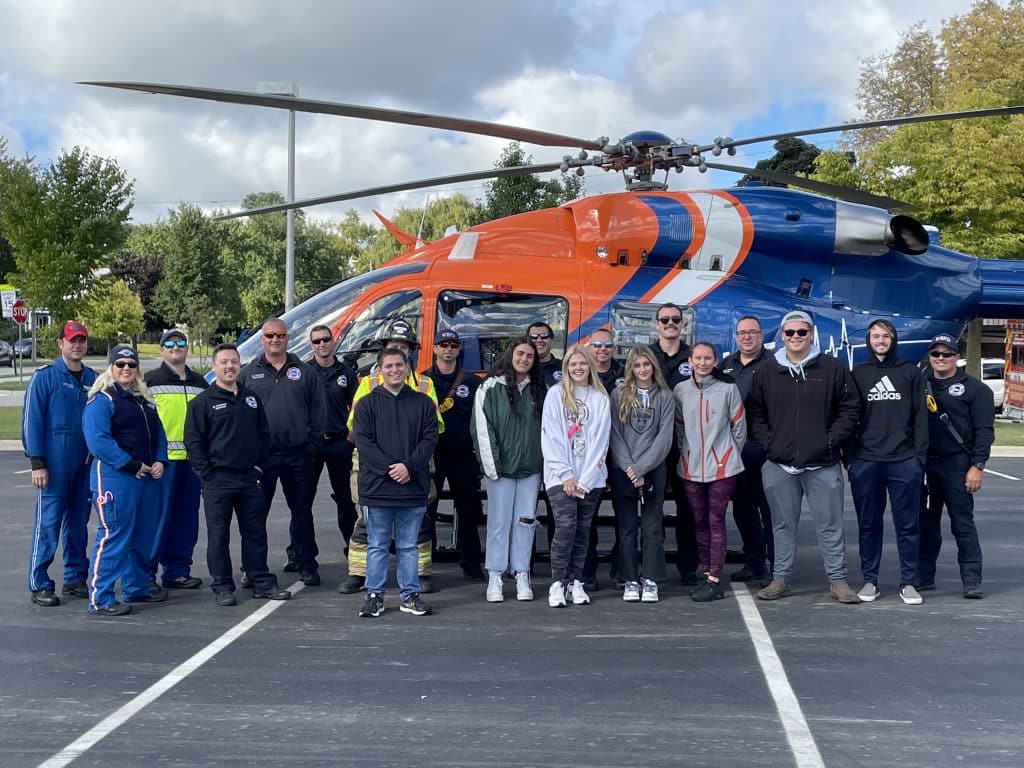 High school class in front of an EMT helicopter.