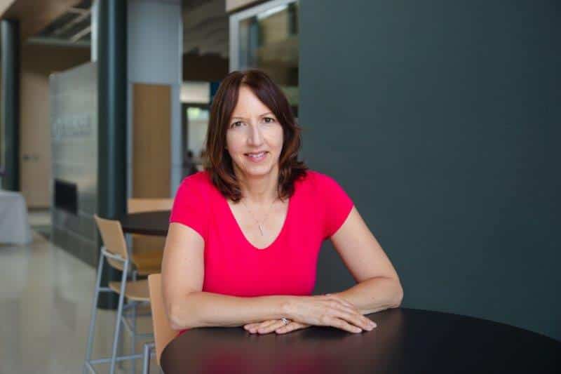 Kelli Karpinski, Business Development Representative, sitting at a high top.