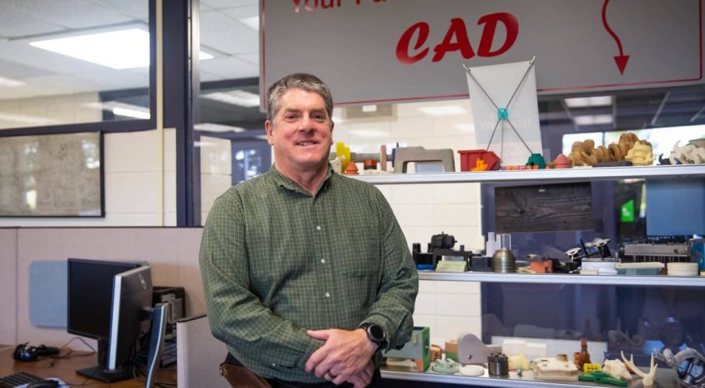 Moraine Park Mechanical Design Technology Instructor, Kim Olson, standing in his lab.