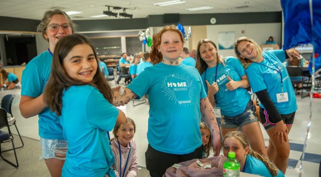 Students wearing the TKC t-shirts and waving to the camera