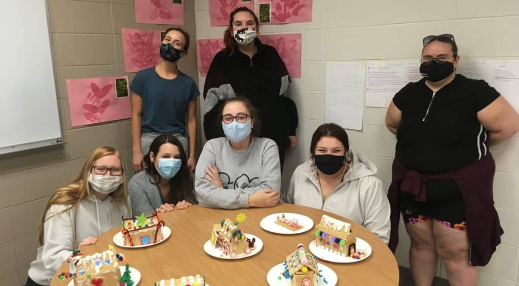 Early Childhood Education students sitting at a table and eating cake.