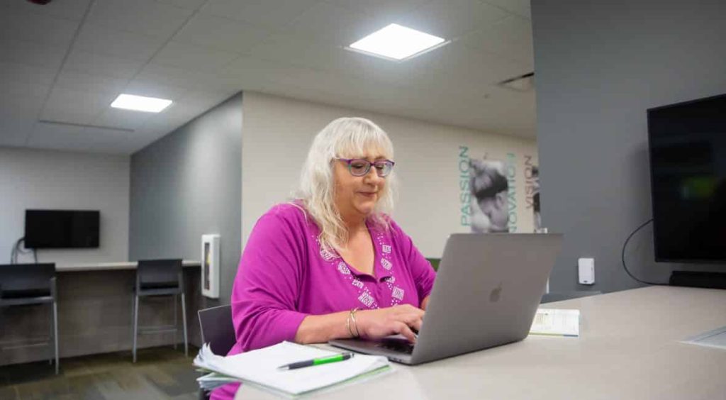 Tutoring Services Specialist, Mary Daley, working on her laptop.