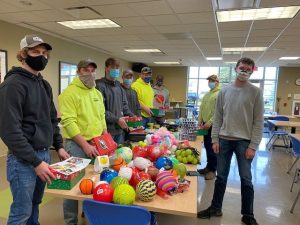 Moraine Park student volunteers standing around a table with toys on it.