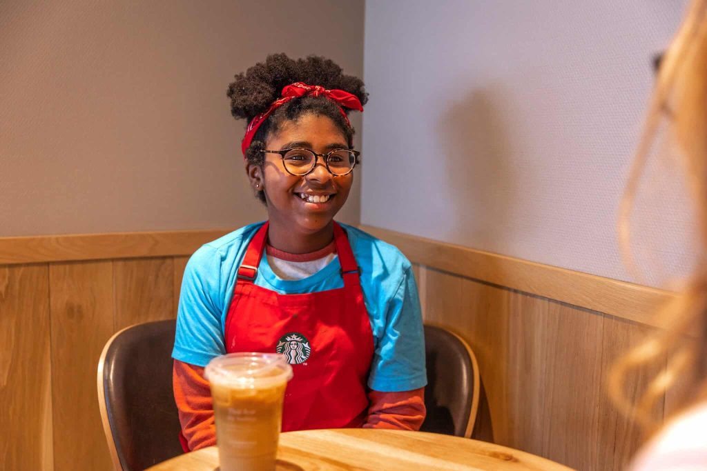 TKC camper smiling with a coffee