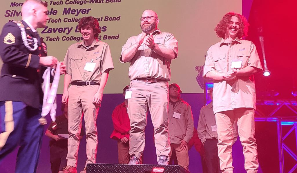 Three Moraine Park students on the poidium