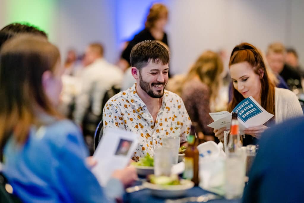 Happy people sitting at a shared table at a networking event.