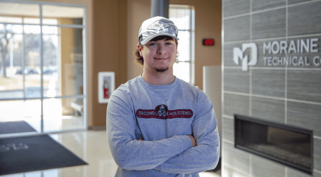 Moraine Park Student Alec Harrison standing in the college entrance confidently looking into the camera.