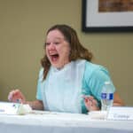 Students is enthusiastically laughing during a hot wing contest.