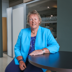Moraine Park President, Bonnie Baerwald, sitting at a high table.
