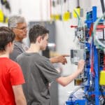 Prospective students working with electrical instructor on wiring