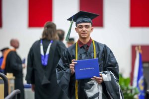 Graduate crossing the stage with diploma