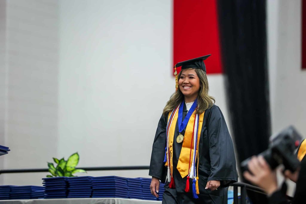 Moraine Park graduate, Mina, walking the stage at commencement.