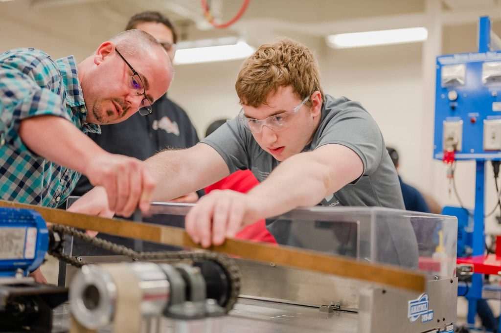 Apprenticeship student learning on a new machine.