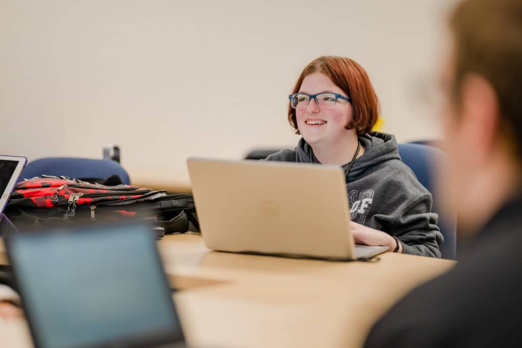 red haired student at big desk with computer