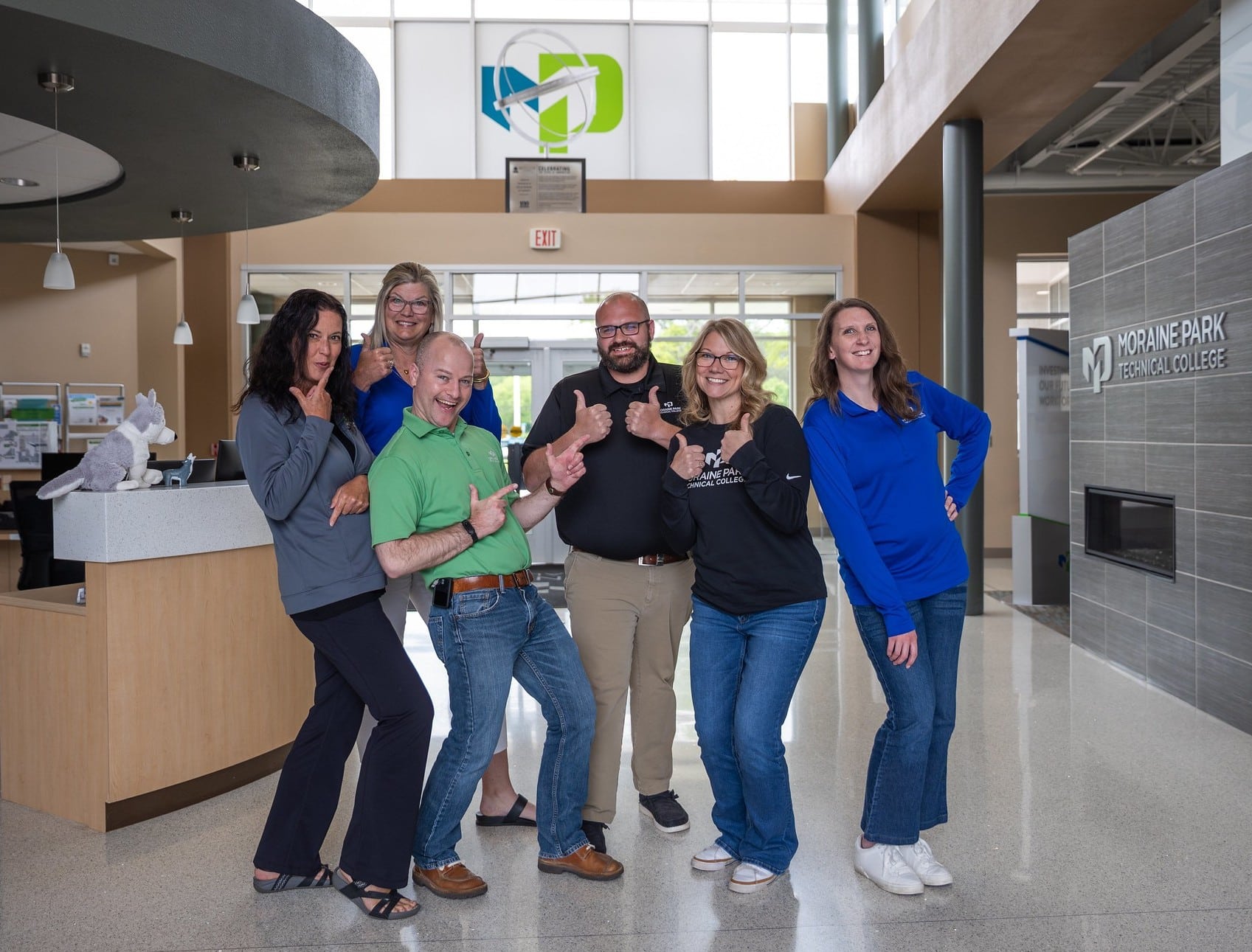 Joyful Moraine Park recruitment team standing next to each other in the Fond du Lac Campus lobby.