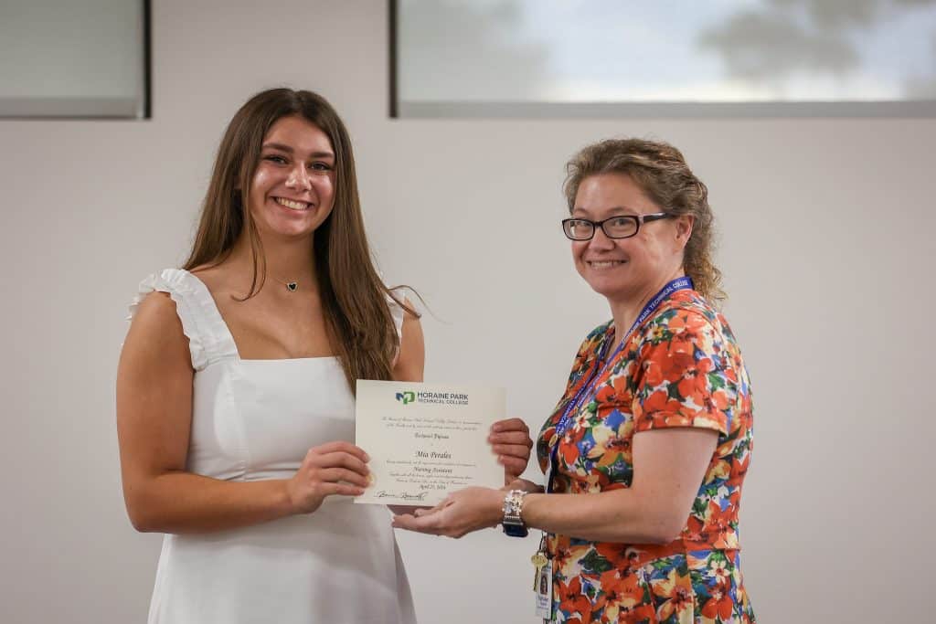 A student receiving the physical Career Academy certification from a Moraine Park staff.