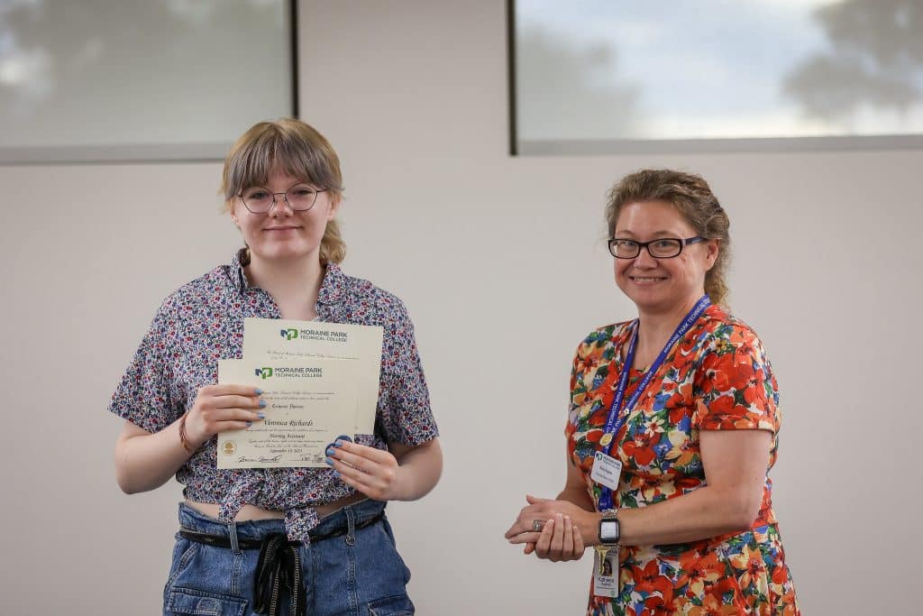 A student receiving the physical Career Academy certification from a Moraine Park staff.