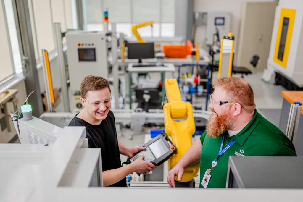 A student getting taught about CNC machines by a Moraine Park instructor.