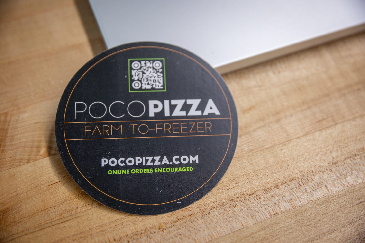 Poco Pizza coaster that says "farm-to-freezer"