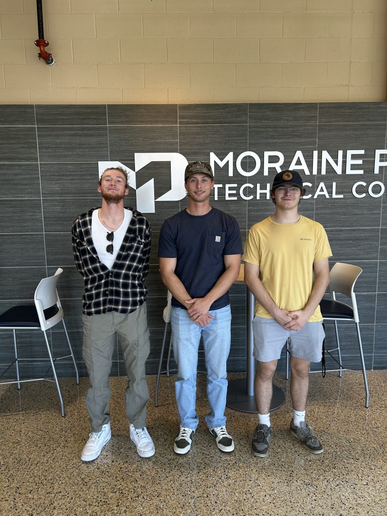From Left to Right: Secretary Chase Richmond, President Maxwell Miltimore, and Vice President Tyler Hawken smiling inside the Beaver Dam Campus main entrance.