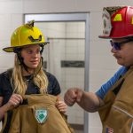 High school student trying on fire protection gear during a Moraine Park Career Experience event.