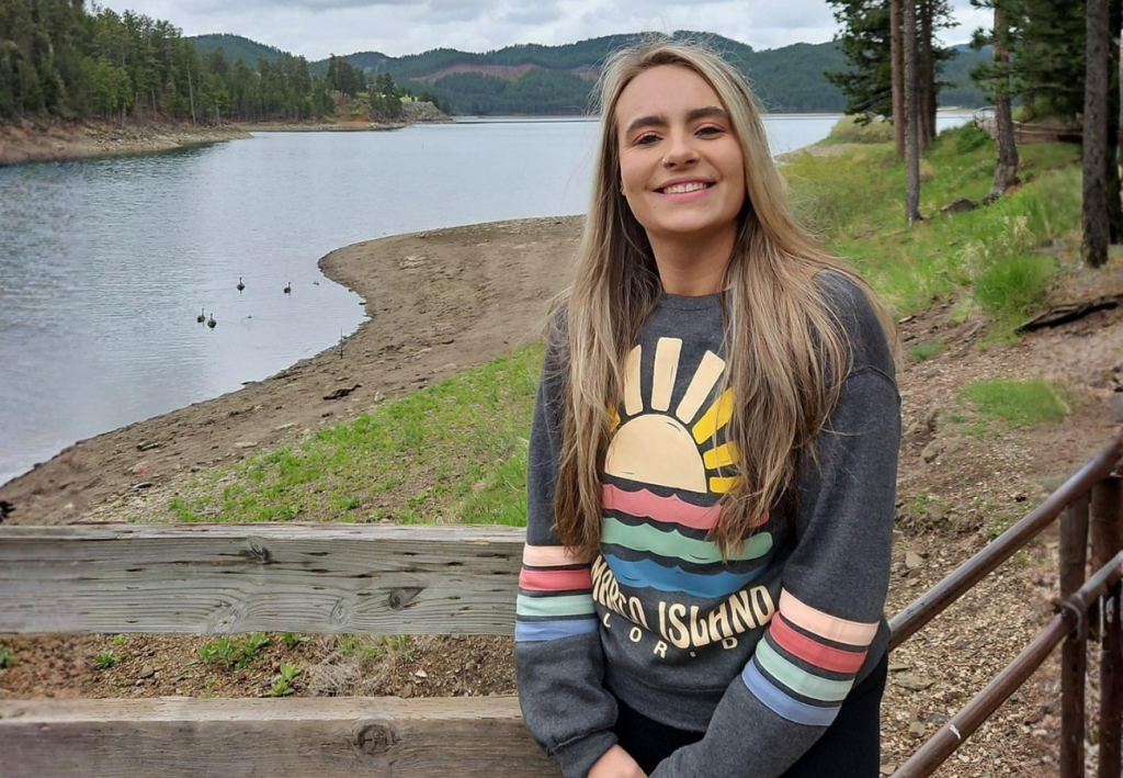 Alison Wolf, human resources student, smiling in nature