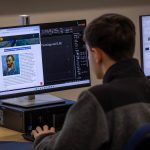 High school student focusing on a Van Gogh image on the desktop computer.