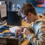 High school student working on a computer's motherboard.