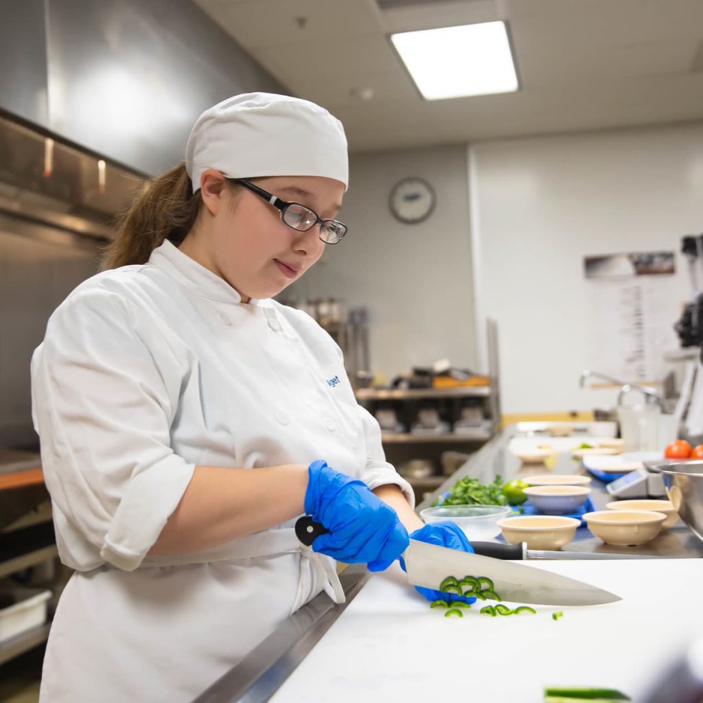 Culinary student chopping up vegetables