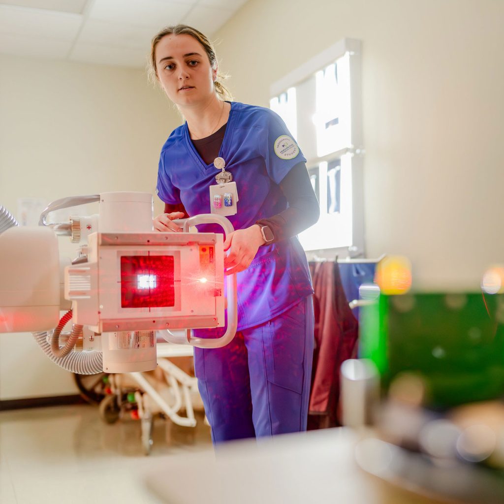 Radiography student working with a machine.